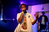 a man in a white shirt is singing into a microphone