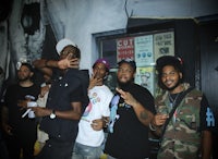 a group of men posing for a picture in front of a wall