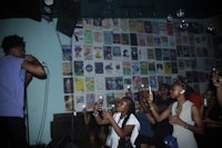 a group of people standing in front of a wall of books