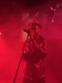 a man in a leather jacket singing into a microphone
