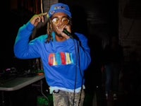 a man in a blue shirt singing into a microphone