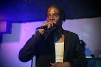 a man in a suit is singing into a microphone