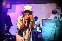 a woman in a hat singing into a microphone